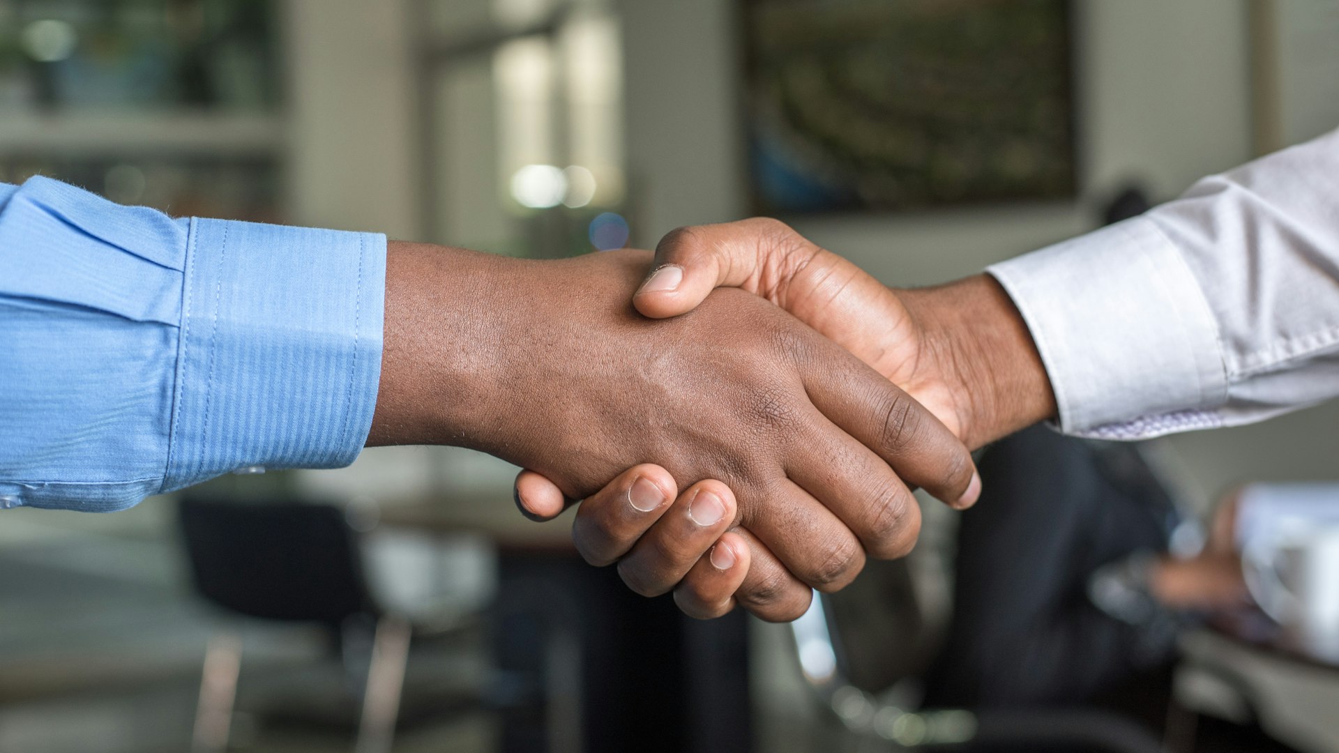 Two people shaking hands after a stakeholder meeting
