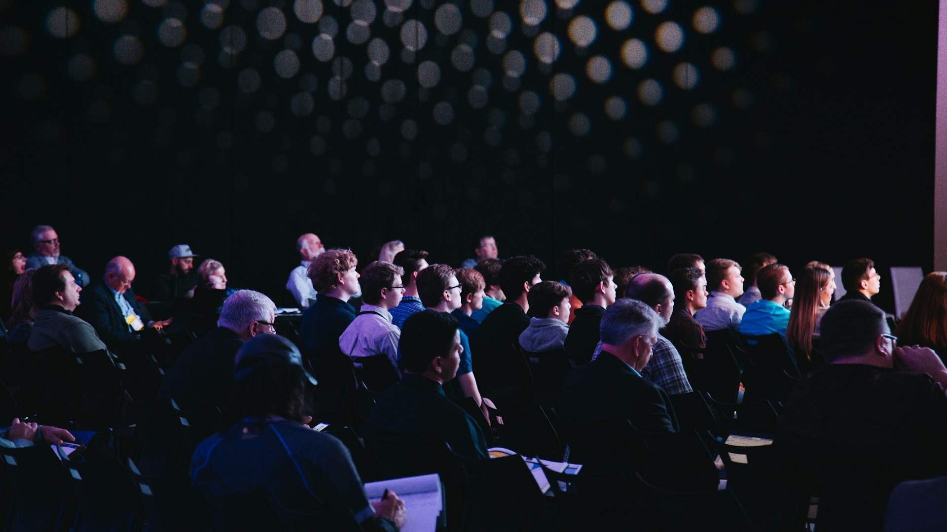 An audience seated together at a community forum event